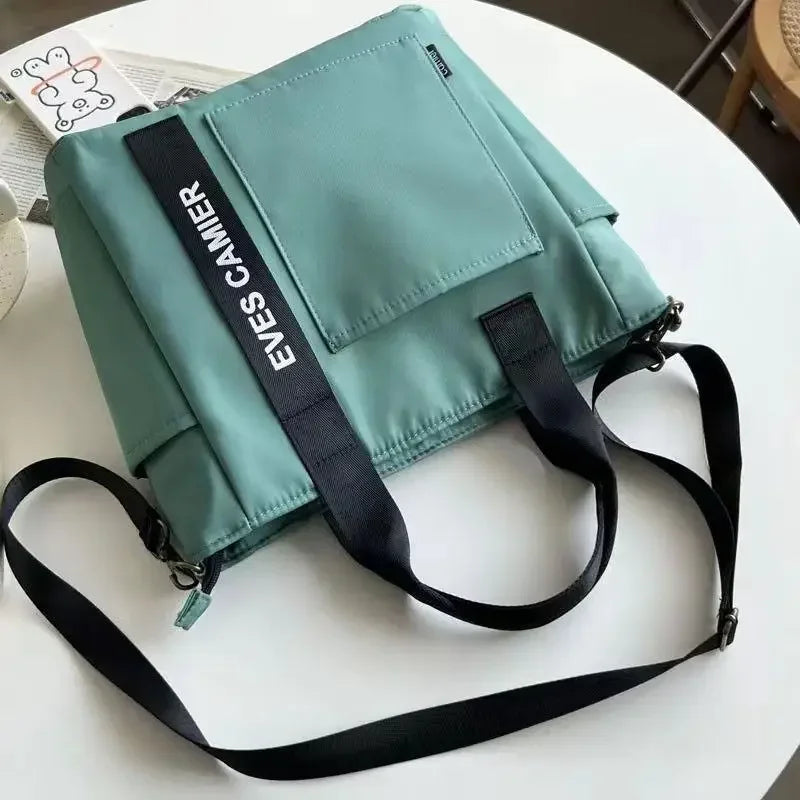 Nuevo bolso de hombro informal de gran capacidad, de nailon, impermeable, de lona, ​​sencillo y moderno, para colegiala.