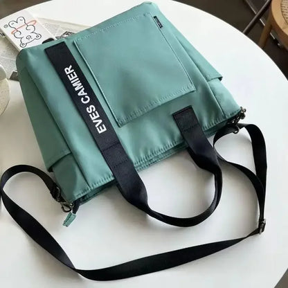 Nuevo bolso de hombro informal de gran capacidad, de nailon, impermeable, de lona, ​​sencillo y moderno, para colegiala.